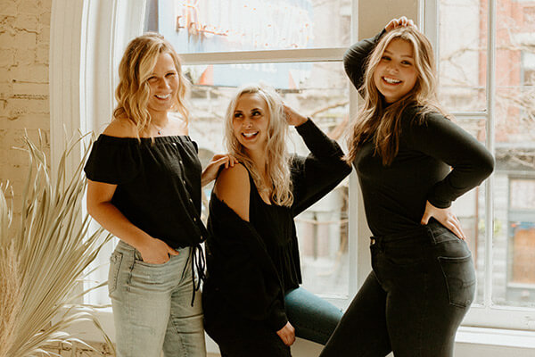 Three blonde women smiling